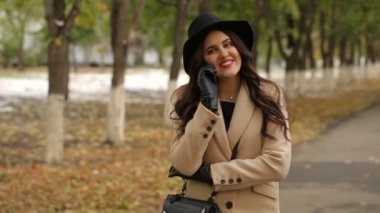 Bej bir palto kız telefonda konuşuyor