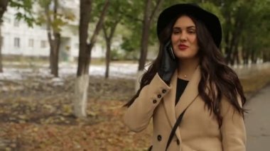 Sokakta ve cep telefonunuza konuşan bir kız geçer