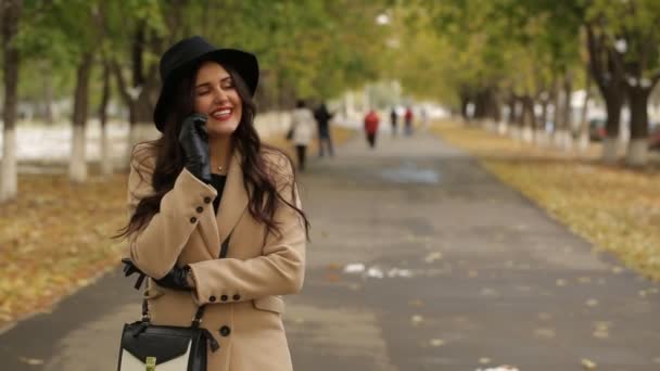 Mulher bonita feliz chamando por telefone na rua de outono — Vídeo de Stock