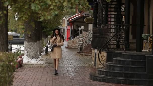 Kız yürüyüş ve telefonda konuşurken şemsiyesi altında — Stok video
