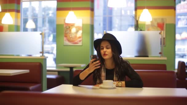 Giovane donna seduta nel caffè e leggere il messaggio — Video Stock