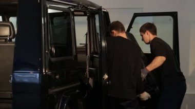 İki adam araba koltuğu dışarı çekti
