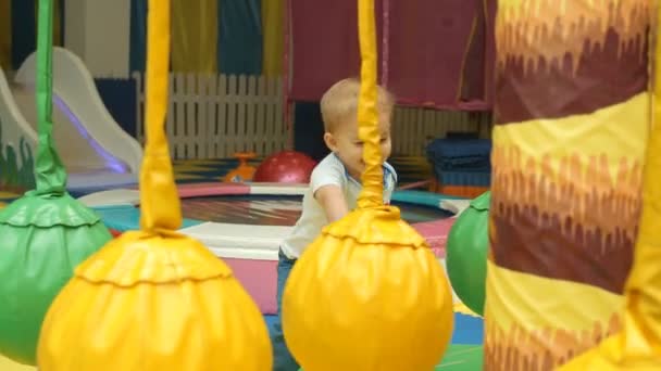 Маленький мальчик веселится на детской площадке — стоковое видео