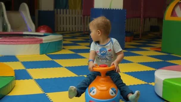 Щаслива дитина грає в ігровий майданчик, іграшковий автомобіль — стокове відео