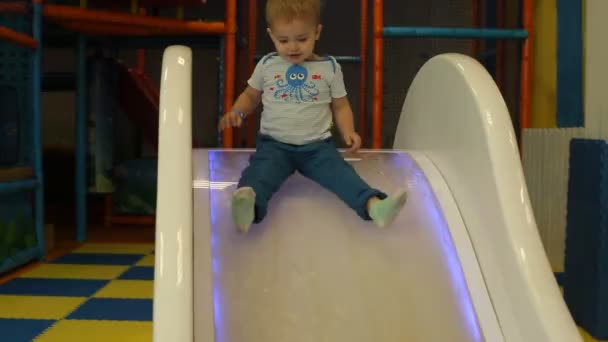 Menino bonito brincando na colina de brinquedo no playground — Vídeo de Stock