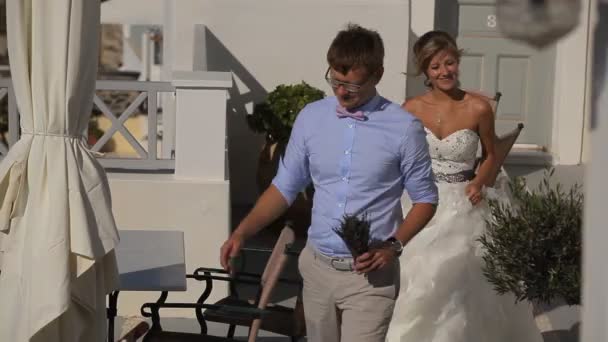 Gelukkige bruid en bruidegom glimlachend en lopen op Santorini — Stockvideo