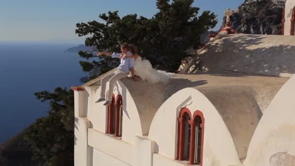 Gli sposi a sedersi sul tetto di una casa — Video Stock