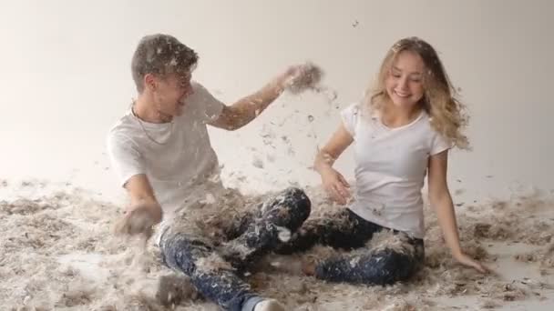 Young couple having fun in the feathers — Stock Video