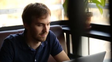 bir adam bir kafede oturan ve bir dizüstü bilgisayar çalışma