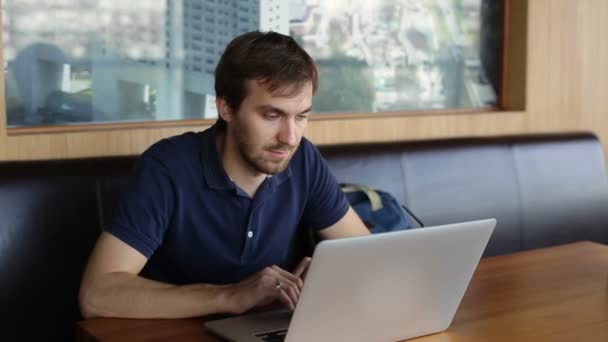 Hombre serio con portátil en la cafetería — Vídeos de Stock