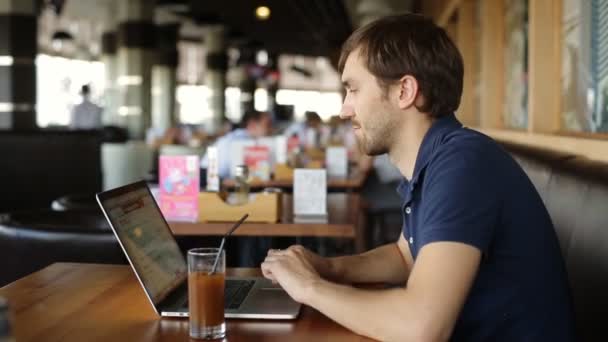 Hombre serio con portátil en la cafetería — Vídeos de Stock
