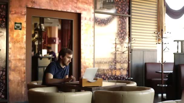 Hombre joven mirando en el ordenador portátil — Vídeos de Stock