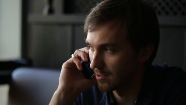 Empresario sentado en la mesa en la cafetería y hablando por teléfono . — Vídeos de Stock