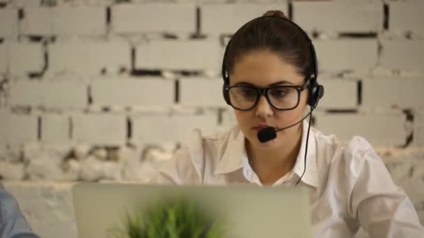 Mujer escribiendo en el ordenador y hablando en el número de teléfono — Vídeos de Stock