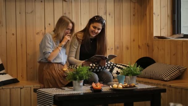 Two girls read magazine and laughing — Stock Video