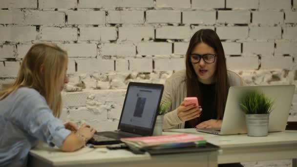 Две курящие деловые женщины, работающие на ноутбуке в офисе — стоковое видео