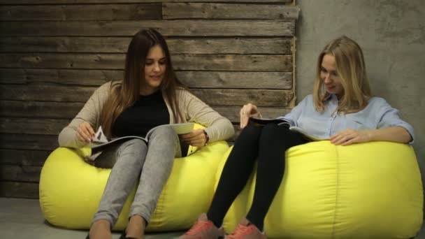 Dos chicas hablando y leyendo una revista — Vídeo de stock