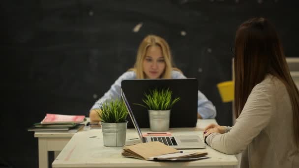 Dvě dívky sedí v kanceláři a mluví — Stock video
