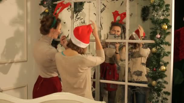 Две красивые девушки веселятся на новогодней вечеринке и делают селфи — стоковое видео