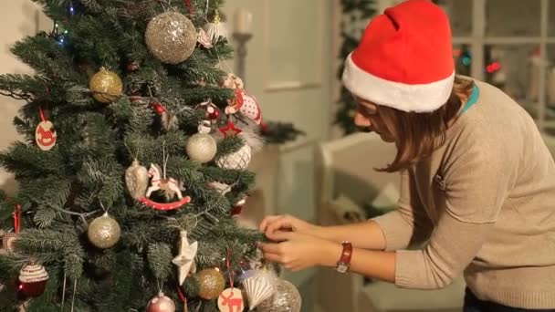 Lány lóg a labdát karácsonyi fa — Stock videók
