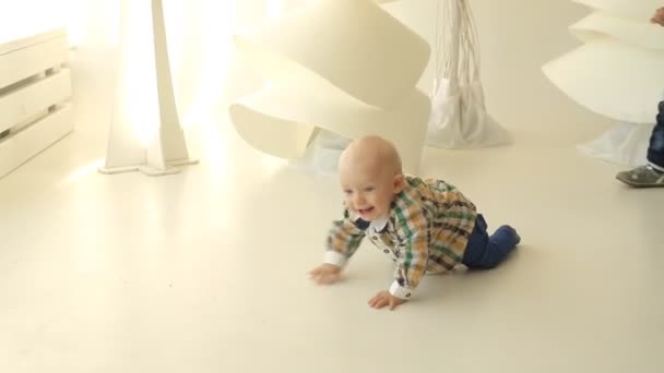 Grappige lachende babyjongen kruipen geïsoleerd op witte studio — Stockvideo