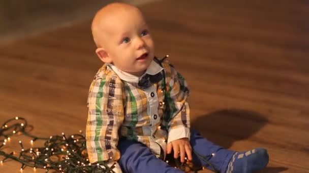 Happy baby spelar med en jul krans — Stockvideo