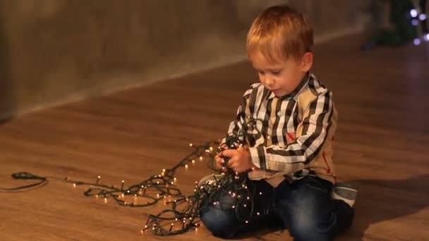 Happy baby spelar med en jul krans — Stockvideo