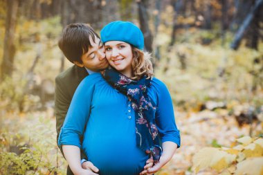 Mutlu evli çift - onun hamile eşi öpüşme koca