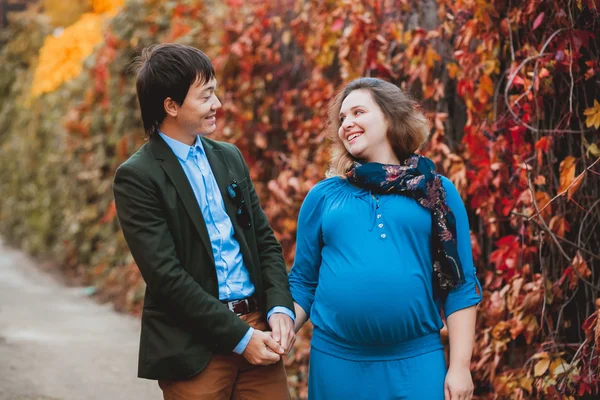 Incinta sorridente coppia passeggiando nel parco — Foto Stock