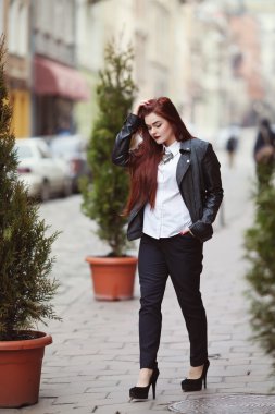 Sokakta yürüyen şık klasik giysiler giyen genç güzel bayan tam vücut portresi. Kız aşağı bakıyor. Artı boyut modeli. Kadın moda konsepti. Tonda