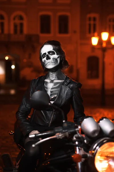 Junge Frau mit Halloween-Make-up sitzt auf dem Motorrad. Straßenporträt — Stockfoto