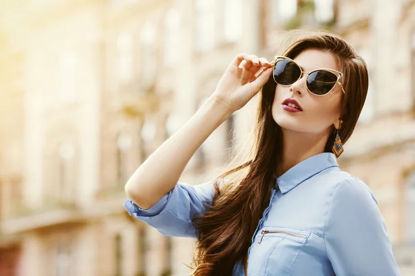 Outdoor portrait of a young beautiful confident woman posing on the street. Model wearing stylish sunglasses. Girl looking up. Female fashion. Sunny day. City lifestyle. — Stock Photo, Image