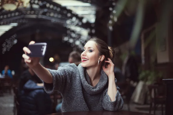 Portrait of a smiling beautiful young woman making selfie photo with her smartphone — Stock Photo, Image