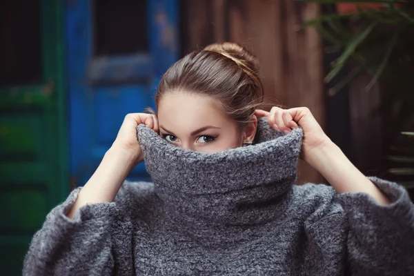 Young woman in a knitted turtleneck sweater covering her face. Close up — Stock Photo, Image