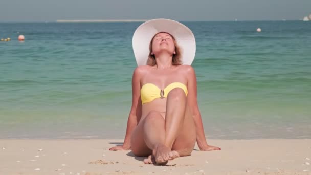 Belle femme sexy prend un bain de soleil sur une plage de sable et prend un bain de soleil — Video