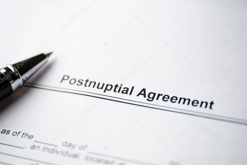 Legal document Postnuptial Agreement on paper with pen.