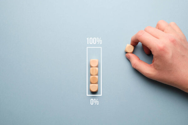 Zero to 100 percent loading bar concept with wooden cubes.