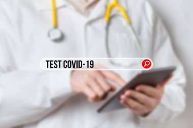 Tabletli bir doktorun arka planındaki arama çubuğunda covid-19 için kavram testi.