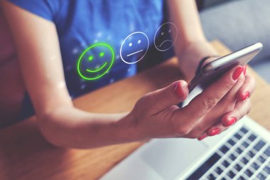 İyi ruh hali konsepti, duygu simgesi ve derecelendirme. Kız akıllı telefon kullanarak bir değerlendirme yapıyor.