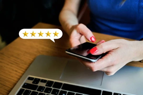 Girl works in the office and gives a five-star rating using a smartphone.