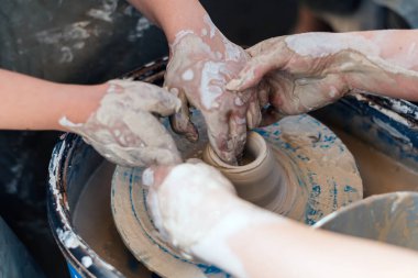 Çömlekçilik konusunda yüksek lisans. Eller kil bir şekil oluşturur.