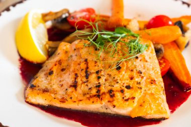 Tabakta sebzeli ızgara somon filetosu.