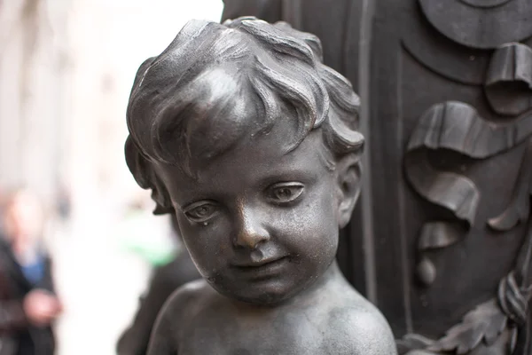 Staty av en pojke av sten i staden — Stockfoto