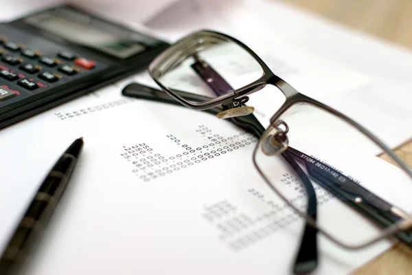 Een stapel facturen, chequeboek, pen en calculator Stockfoto