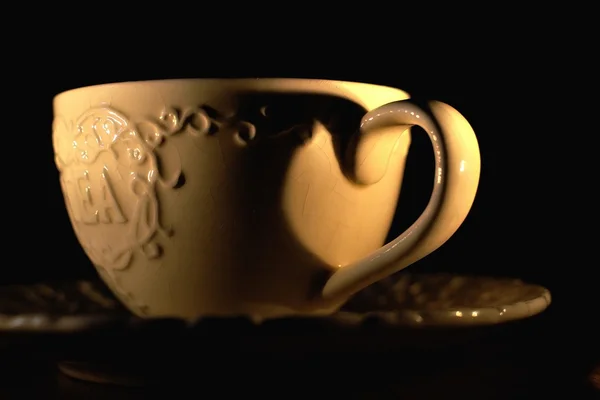 Porcelain cup of tea with an inscription by candlelight — Stock Photo, Image