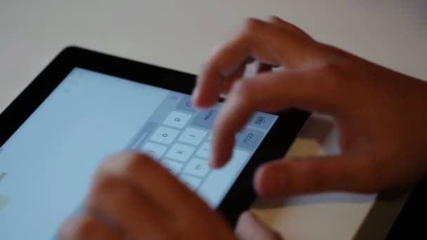 Homme tapant sur la tablette à la table 