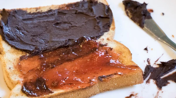 Tasty bread toast and strawberry jam with chocolate spread — Stock Photo, Image