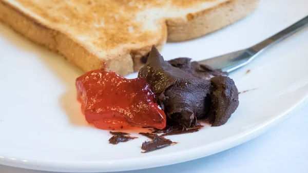 The close up of tasty bread toast and strawberry jam with chocolate spread — Stock Photo, Image