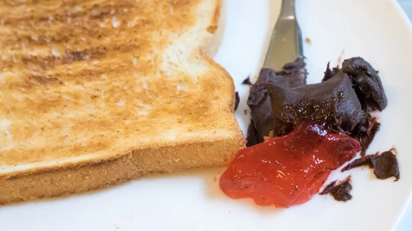 The close up of tasty bread toast and strawberry jam with chocolate spread — Stock Photo, Image