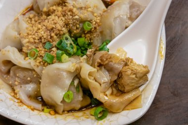 Tayvan 'da Tayvan usulü geleneksel haşlanmış baharatlı, kokmuş tofu wonton mutfağı. Tayvan, Tayvan' daki yemek pazarında eski ahşap masa üzerinde kaşık..